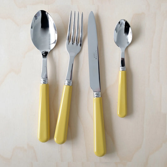 Sabre Paris Pop cutlery set in yellow corn on a wooden surface.