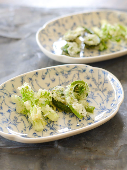 Studio M' Chamomile Oval Plate in white porcelain, featuring a vintage blue floral pattern and a gently curved traditional Japanese Mokkou shape. Serving side dishes.