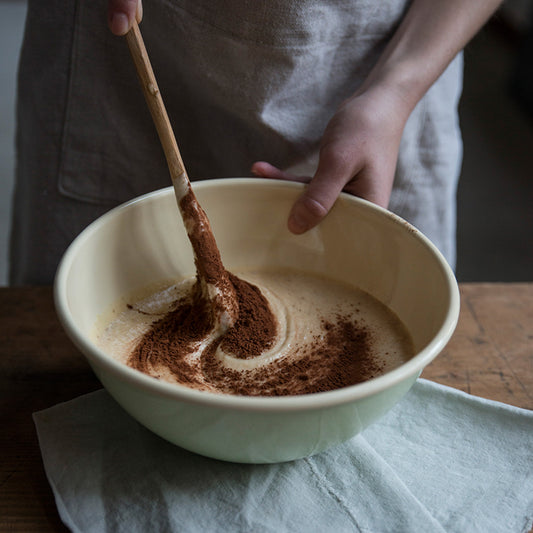 Riess 22cm porcelain enamel fruit and salad bowl in a soft light green, being used to prepare dessert.