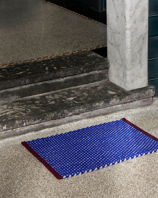 A lifestyle shot of the HAY Door Mat in Royal Blue.
