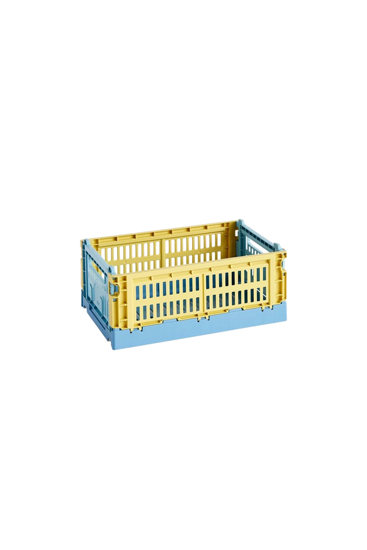 Side-angle view of the small HAY Colour Crate Mix in a muted dusty yellow, showcasing its stackable, ventilated industrial design made from recycled plastic.