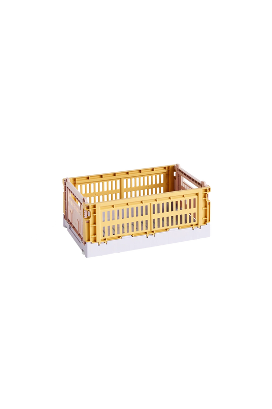 Side-angle view of the small HAY Colour Crate Mix in a vibrant golden yellow, showcasing its stackable, ventilated industrial design made from recycled plastic.