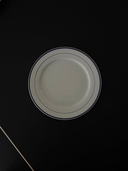 Tuxton round plate with three blue lines hand painted on the rim.