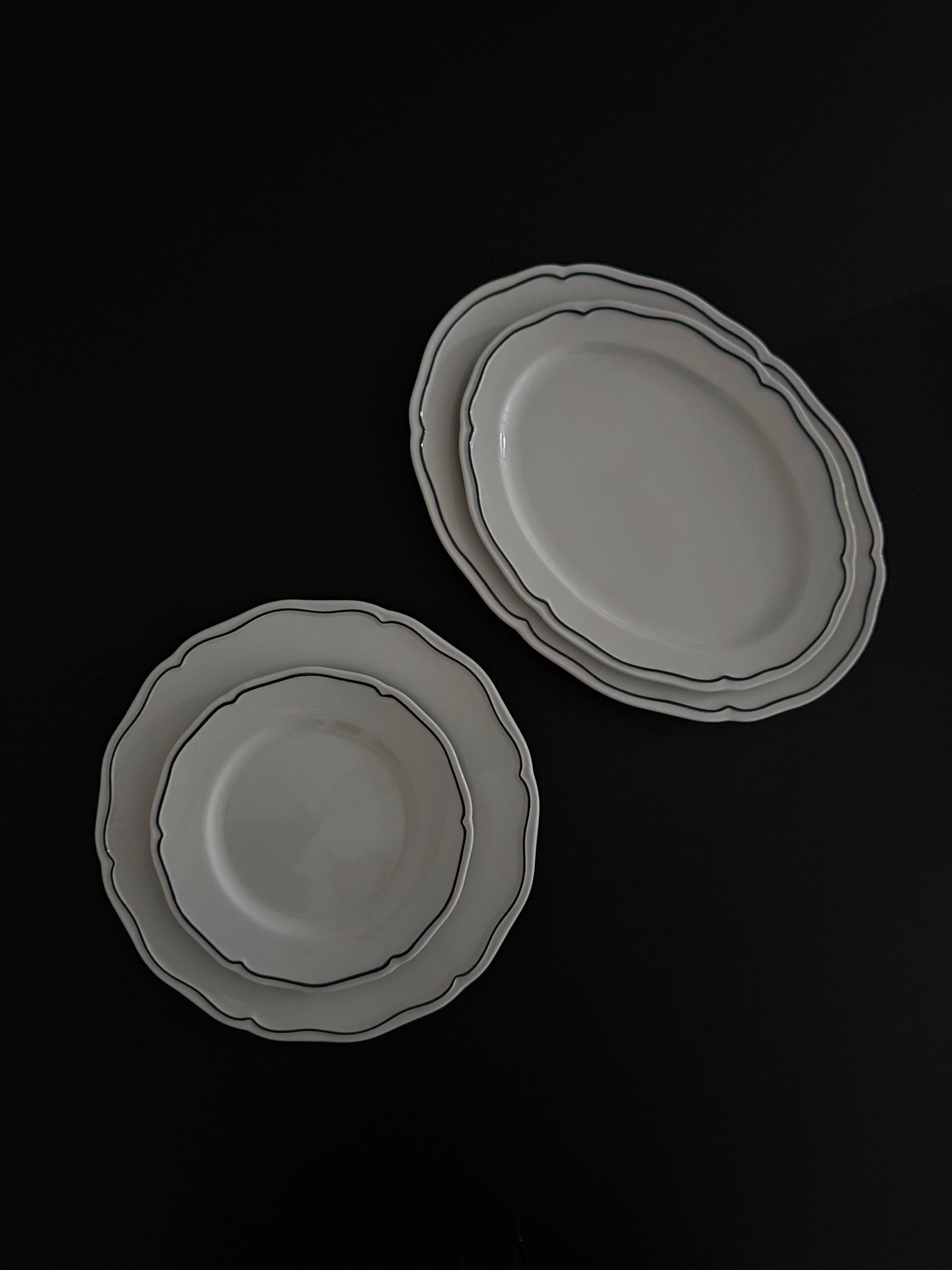 Tuxton Charleston oval serving platters and round plates in American White with embossed scalloped edges.