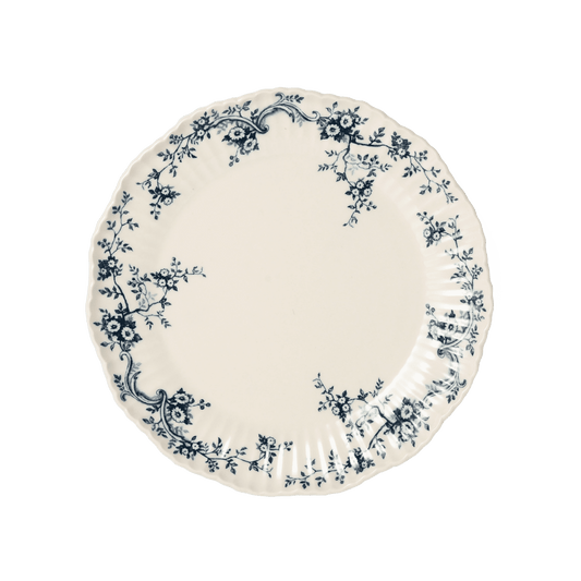 A pack shot of Studio M' Audrey 200 Plate in indigo porcelain, featuring a scalloped lace-like rim and an English garden-inspired floral relief pattern.