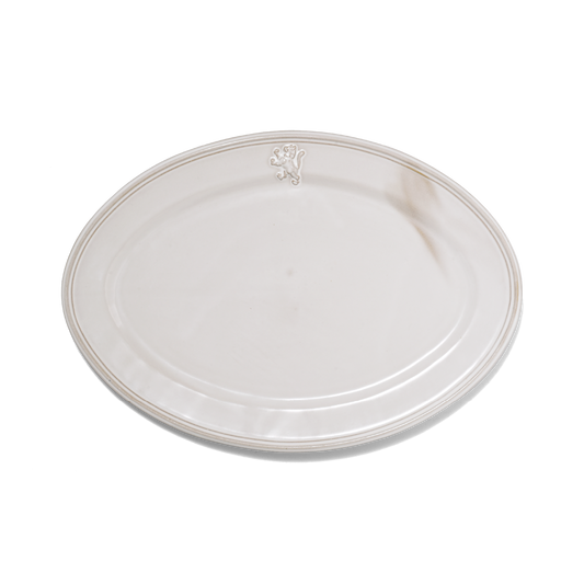 A pack shot of Studio M' Malta Oval Plate 28cm in a stunning white glaze, featuring a sleek, almond-like oval shape and an embossed vintage-style cat crest on the rim.
