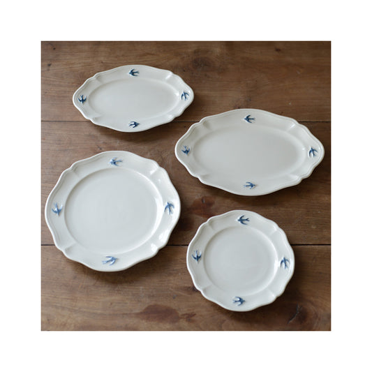 A collection of Studio M' Early Bird round plates and oval plates. 