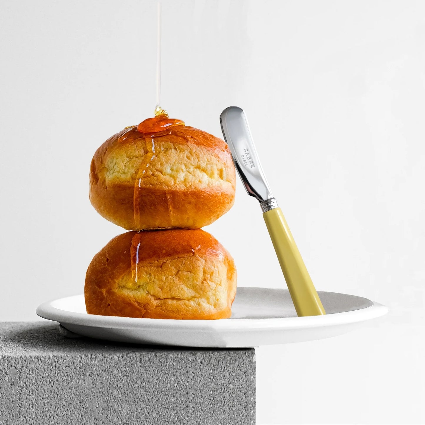 Two buns with Sabre Paris Pop Unis Butter Spreader in yellow corn