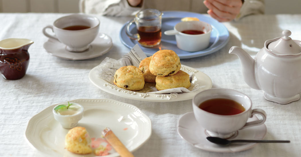 Studio M Creamware Plate L served with fresh fruit scone and butter and jam on a white table cloth. 