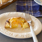Studio M Creamware Plate L served with fresh fruit tart and a white dessert fork on a grey bench.