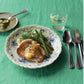 A close-up shot of Studio M' Moment Plate 24cm in a beautiful blue glaze on a table setting.