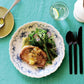 Studio M' Moment Plate 24cm in a beautiful blue glaze, on a table setting. 
