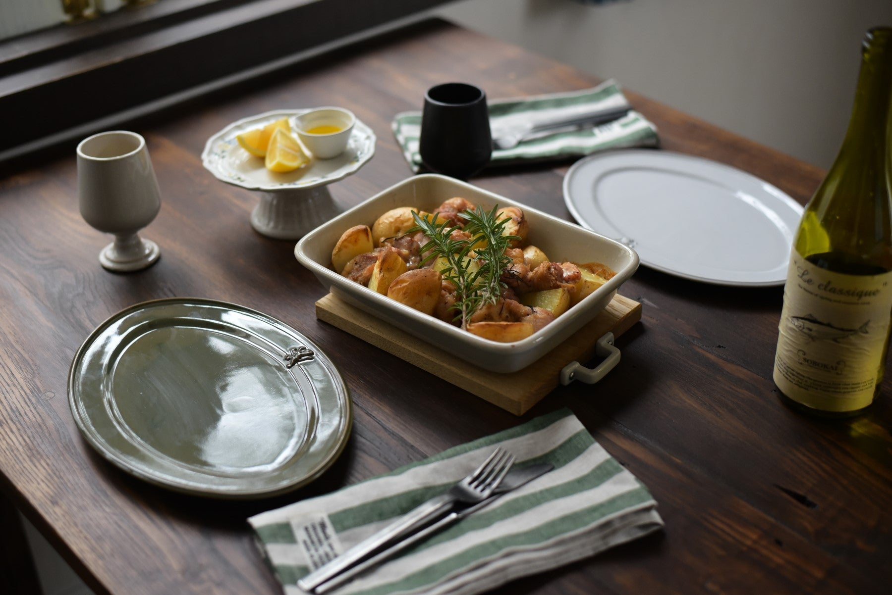 Studio M' Malta Oval Plate 28cm in a stunning white glaze, on a table setting paired with same plate in green. 