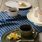 Studio M' Malta Oval Plate 28cm in an earthy green glaze, in an afternoon tea table seeting.