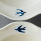 A close up shot of the hand painted bird on the rim of the Studio M' Early Bird Bowl 17cm. 