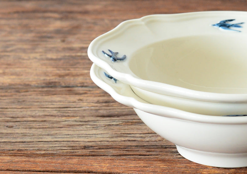 A close-up shot of the rims of stacked Studio M' Early Bird 170 porcelain bowls.