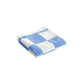 Folded HAY organic cotton wash cloth featuring a classic sky blue and white check pattern, showcasing its soft, absorbent terry texture.