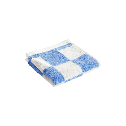Folded HAY organic cotton wash cloth featuring a classic sky blue and white check pattern, showcasing its soft, absorbent terry texture.