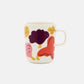 Side-angle view of the Marimekko Oiva 250ml white stoneware mug featuring the Kukasta Kukkaan abstract floral and leaf pattern in pink, terracotta, and plum.