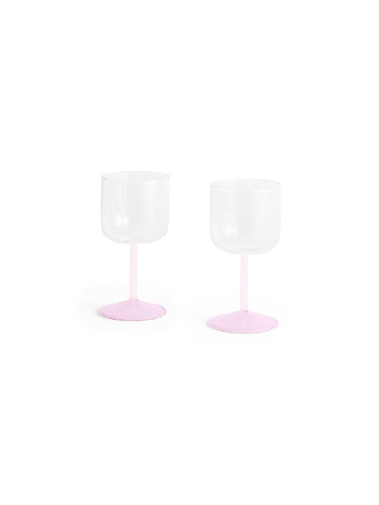 Side-angle view of a set of two HAY Tint Wine Glasses, showcasing minimalist clear borosilicate glass bowls resting on delicate stems in jade light pink and light pink.