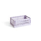 Side-angle view of the small HAY Colour Crate in a soft lavender purple, showcasing its stackable, ventilated industrial design made from recycled plastic.