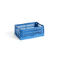 Side-angle view of the small HAY Colour Crate in a vibrant electric blue, showcasing its stackable, ventilated industrial design made from recycled plastic.
