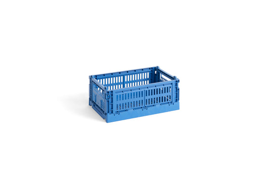 Side-angle view of the small HAY Colour Crate in a vibrant electric blue, showcasing its stackable, ventilated industrial design made from recycled plastic.