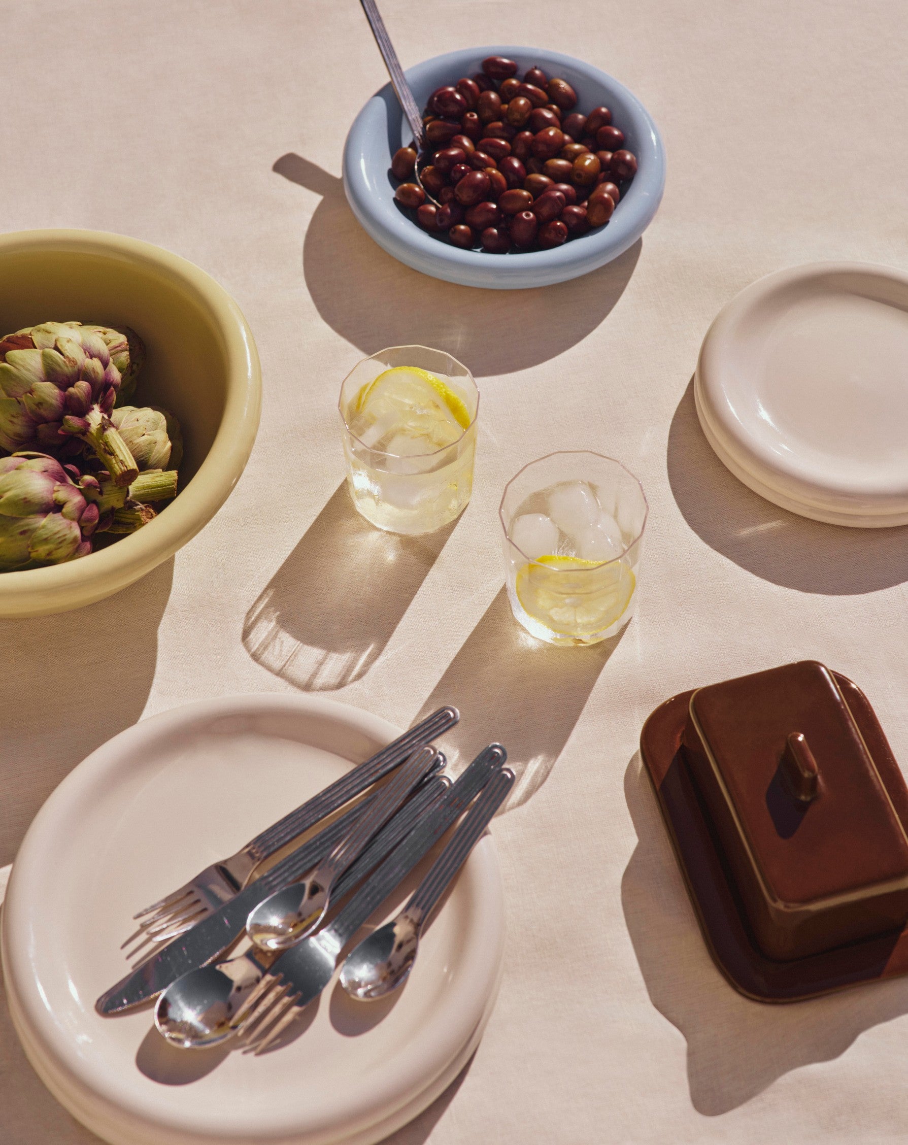 Table setting with Hay Barro collection, glasses, and utensils on a light surface