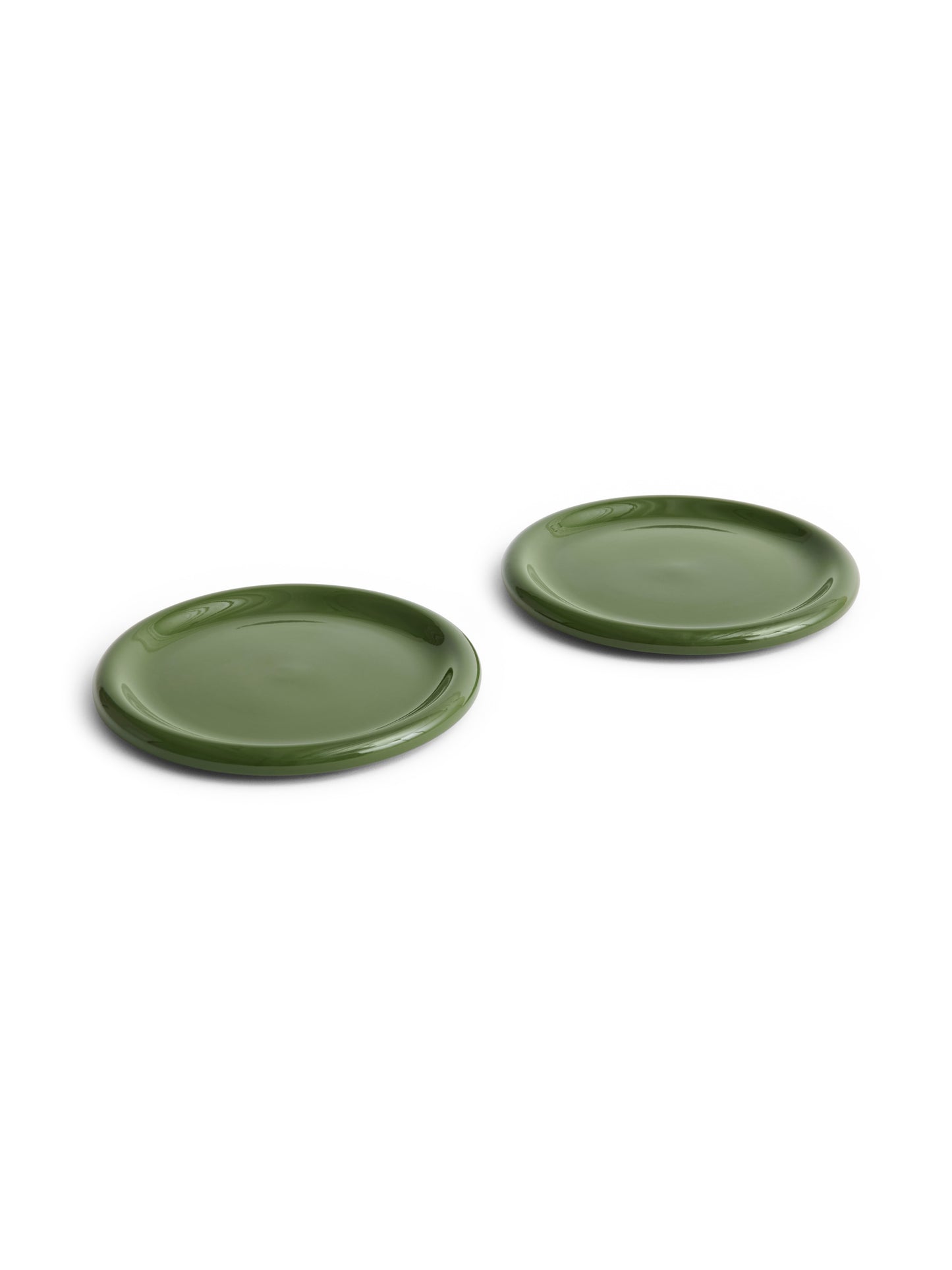 Side angle of two large 24cm HAY Barro terracotta dinner plates showcasing a fresh high-gloss green glaze and distinctive natural rolled edges in Green.