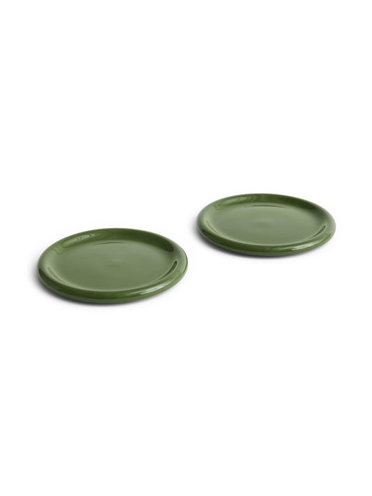 Side angle of two large 24cm HAY Barro terracotta dinner plates showcasing a fresh high-gloss green glaze and distinctive natural rolled edges in Green.