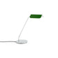 Side-angle view of the HAY Apex Desk Lamp featuring a folded steel shade in emerald green, contrasted against a sleek, chrome-plated angled base.
