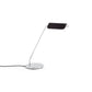 Side-angle view of the HAY Apex Desk Lamp featuring a folded steel shade in matte iron black, powerfully contrasted against a sleek, chrome-plated angled base.