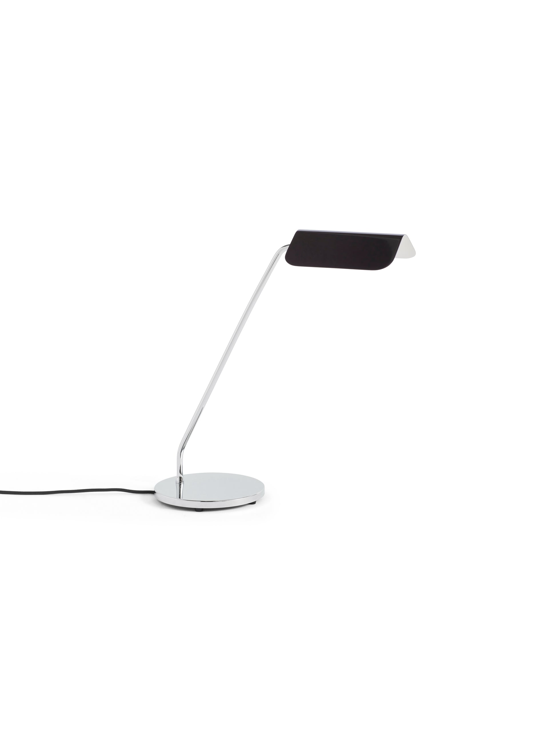 Side-angle view of the HAY Apex Desk Lamp featuring a folded steel shade in matte iron black, powerfully contrasted against a sleek, chrome-plated angled base.