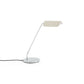 Side-angle view of the HAY Apex Desk Lamp featuring a folded steel shade in soft oyster white, beautifully contrasted against a sleek, chrome-plated angled base.