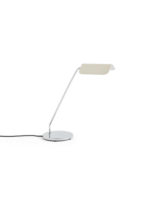 Side-angle view of the HAY Apex Desk Lamp featuring a folded steel shade in soft oyster white, beautifully contrasted against a sleek, chrome-plated angled base.
