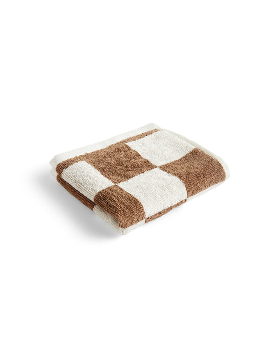 Folded HAY organic cotton wash cloth featuring a classic cappuccino brown and white check pattern, showcasing its soft, absorbent terry texture.