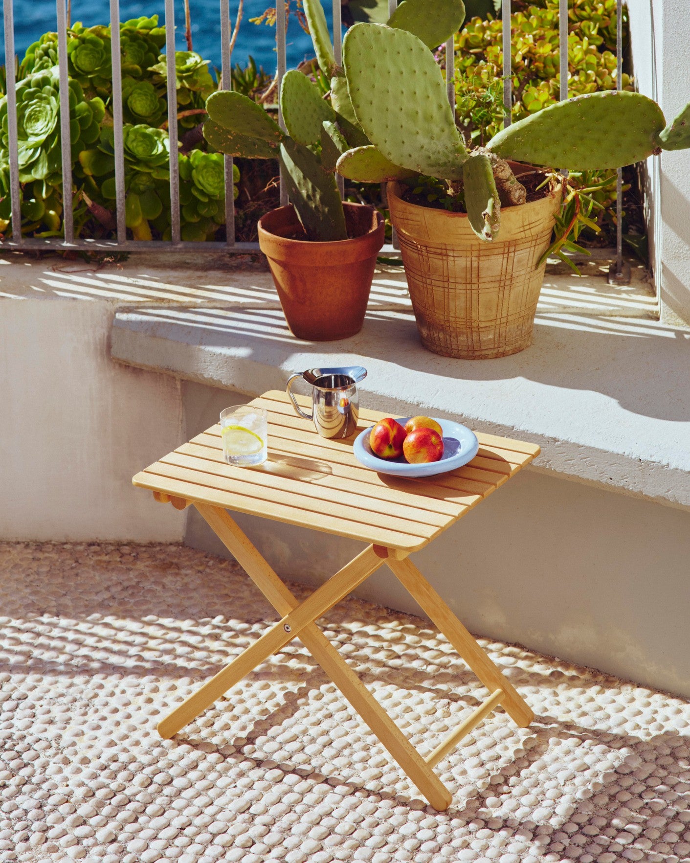 A modern table setting featuring light blue Hay Barro bowl in the balcony.
