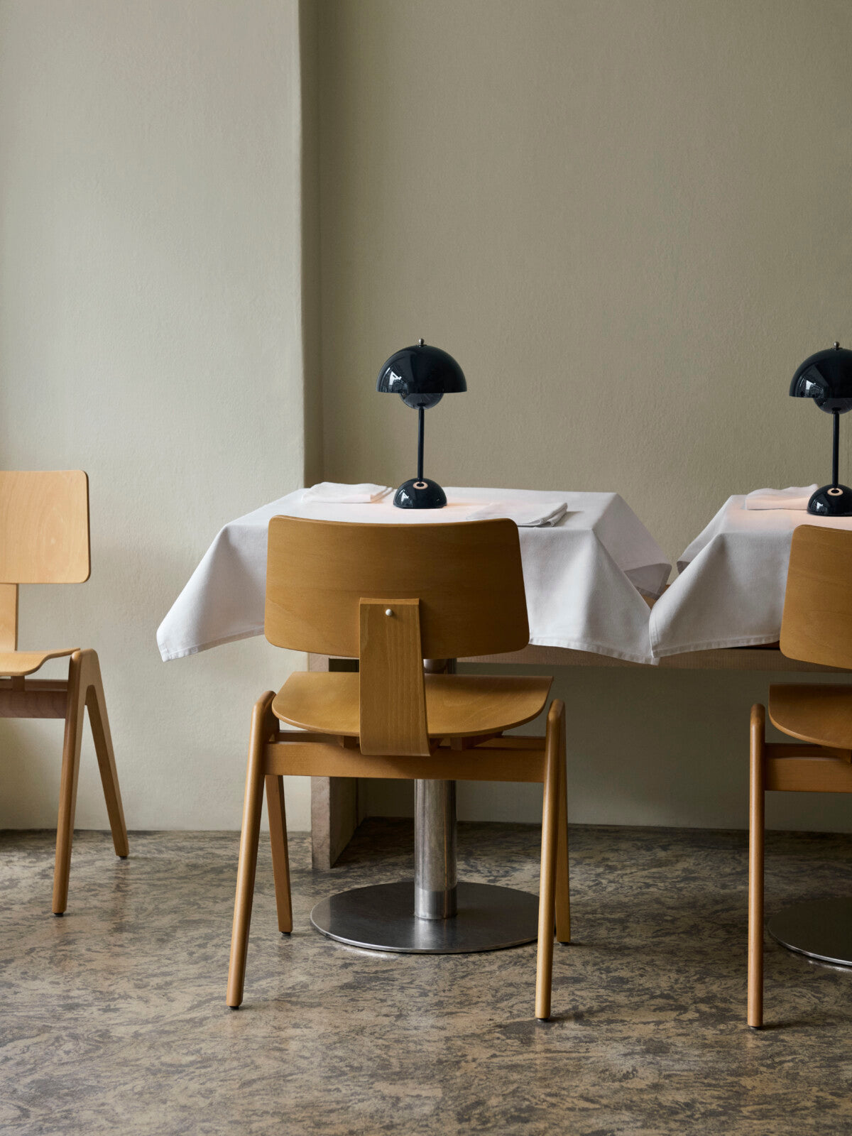 &Tradition Verner Panton Flowerpot VP9 Portable Table Lamp in Steel Blue on white table cloth against a  subtle khaki wall