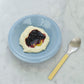 HAY Barro terracotta bowl set of two in high gloss light blue glaze by designer Rui Pereira, paired with HAY yellow spoon.