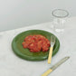 Hay Barro plate 18cm in Green with smashed tomotoes, yellow fork and knife on a white tablecloth.