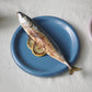 24cm HAY Barro terracotta dinner plate in dark blue serving a fish dish. 
