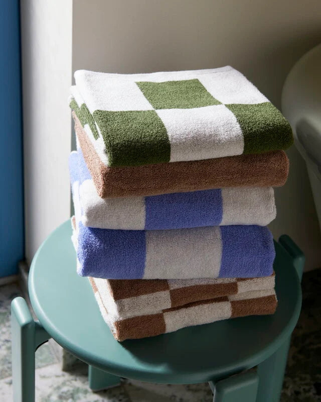 A lifestyle shot of HAY organic cotton wash clothes, available in multiple colours.