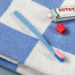 HAY Tann toothbrush blue on a blue check hand towel next to a toothbrush paste.