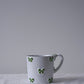 CARRON Paris handmade white ceramic Nœud-Nœud Trianon mug featuring a hand-painted leaf green bow handle detail