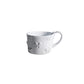 Carron Paris ceramic mug featuring delicate embossed small bows, handcrafted in France for coffee and tea.