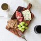 Studio M Japanese solid walnut cutting board collection in oblong medium size, serving a cheese platter. 