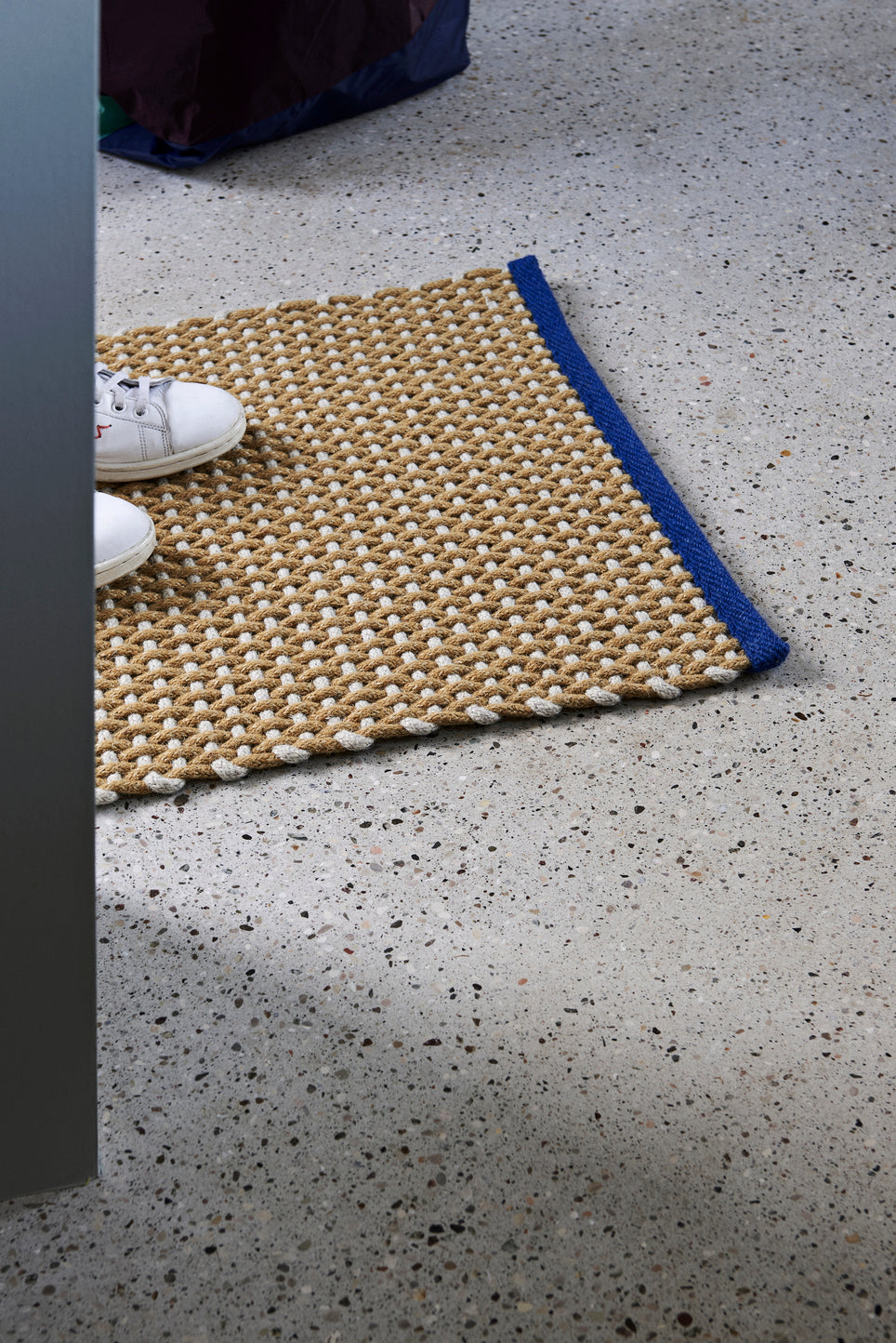 A lifestyle photo of the Hay door mat in yellow.