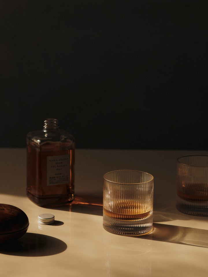 Whiskey served in ferm LIVING Ripple clear glass tumbler on kitchen benchtop.