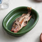HAY Barro large green oval dish serving roasted feast on contemporary dining table, serving a fish.