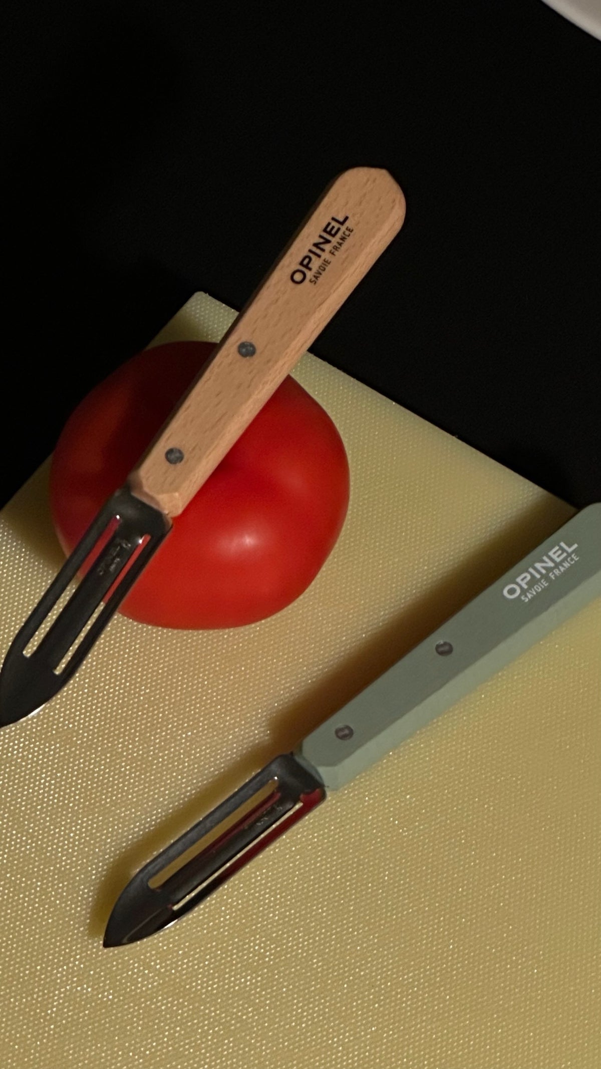 Opinel N115 peeler in Natural and Khaki on Hay cutting board.